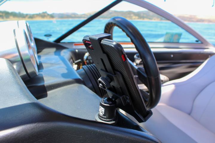 Mob Mount Switch Magnetic attached to boat dashboard holding a phone